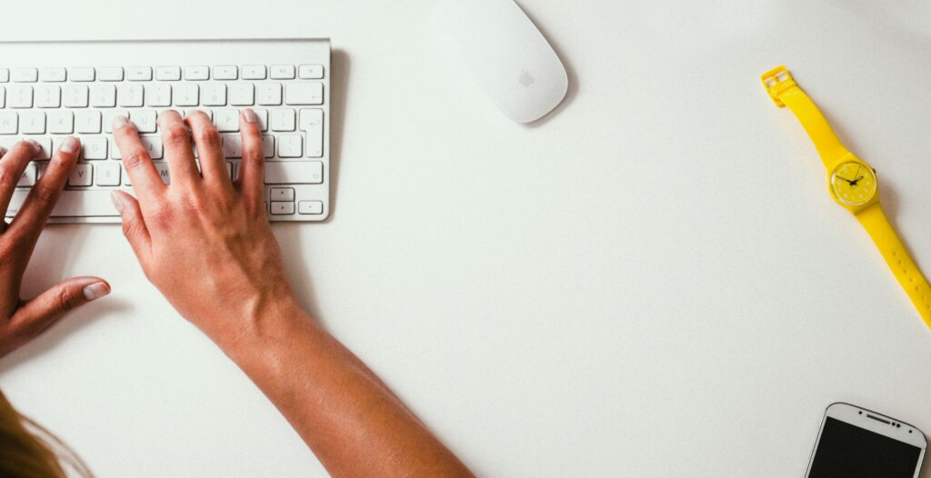 hands typing on an apple keyboard